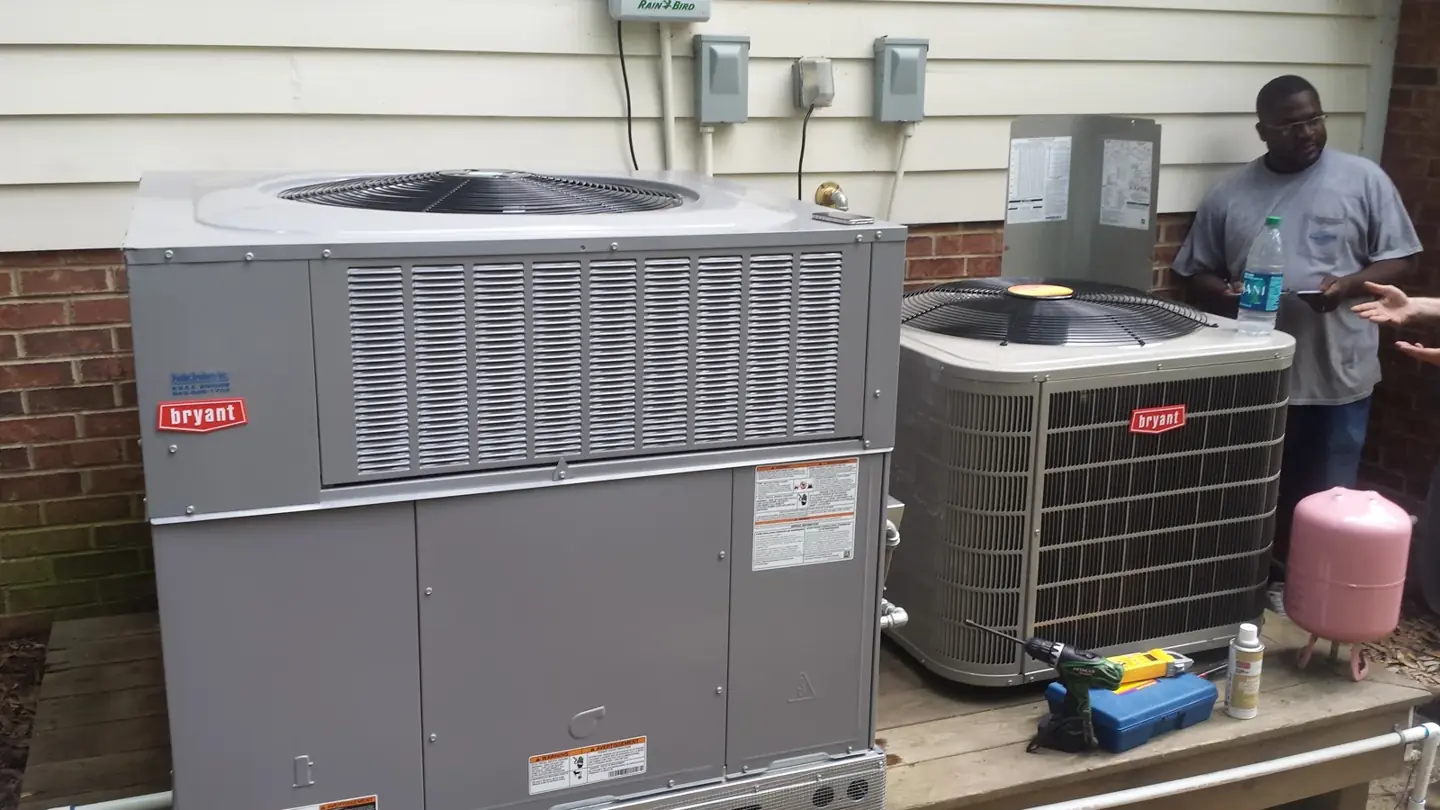 HVAC technician working beside outdoor Bryant heating and cooling units